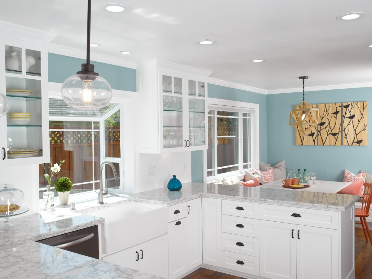 This kitchen features white shaker cabinets with engineered quartz counter top. Customer selected a new garden window, recessed lights, crown moldings, and acacia flooring to brighten the kitchen.